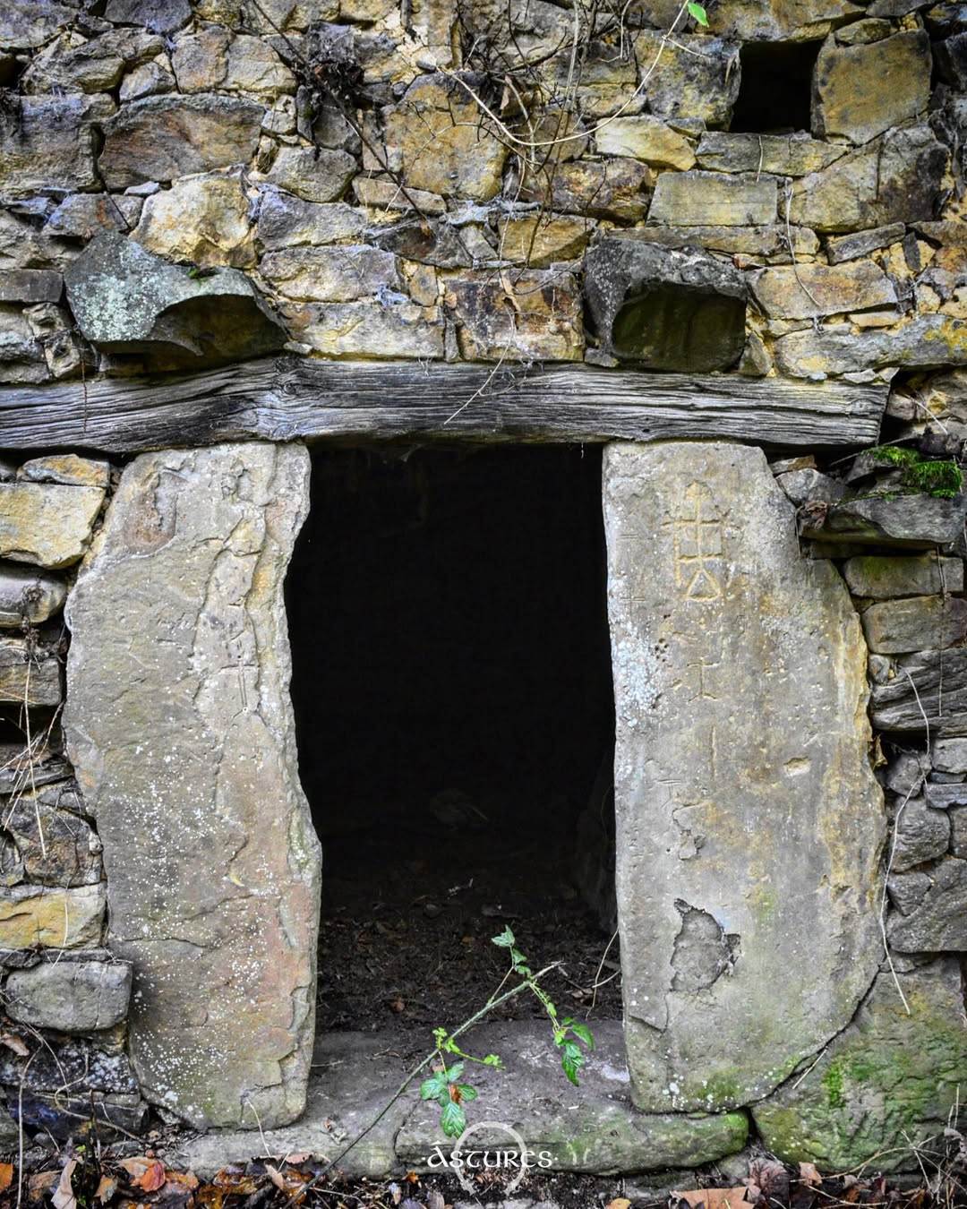 Piedras con grabados de distinta época reutilizadas en una entrada de una cuadra en Asturias.