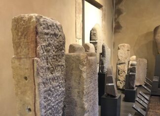Lápida dedicada a Mitra en La Isla, Colunga, junto a otras de la colección permanente del Museo Arqueológico de Asturias.
