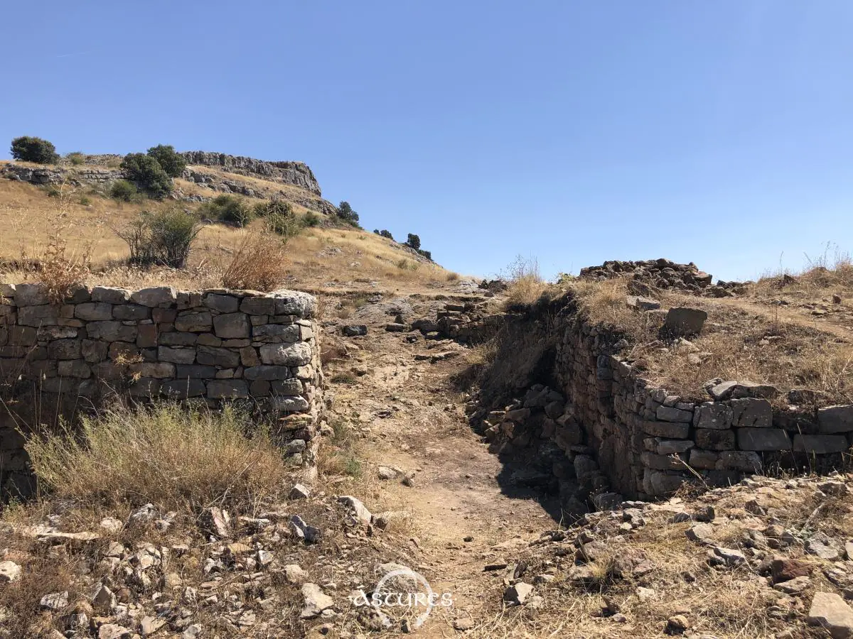 Entrada a la murallla del la Peña del Castro y la cima de la elevación al fondo.